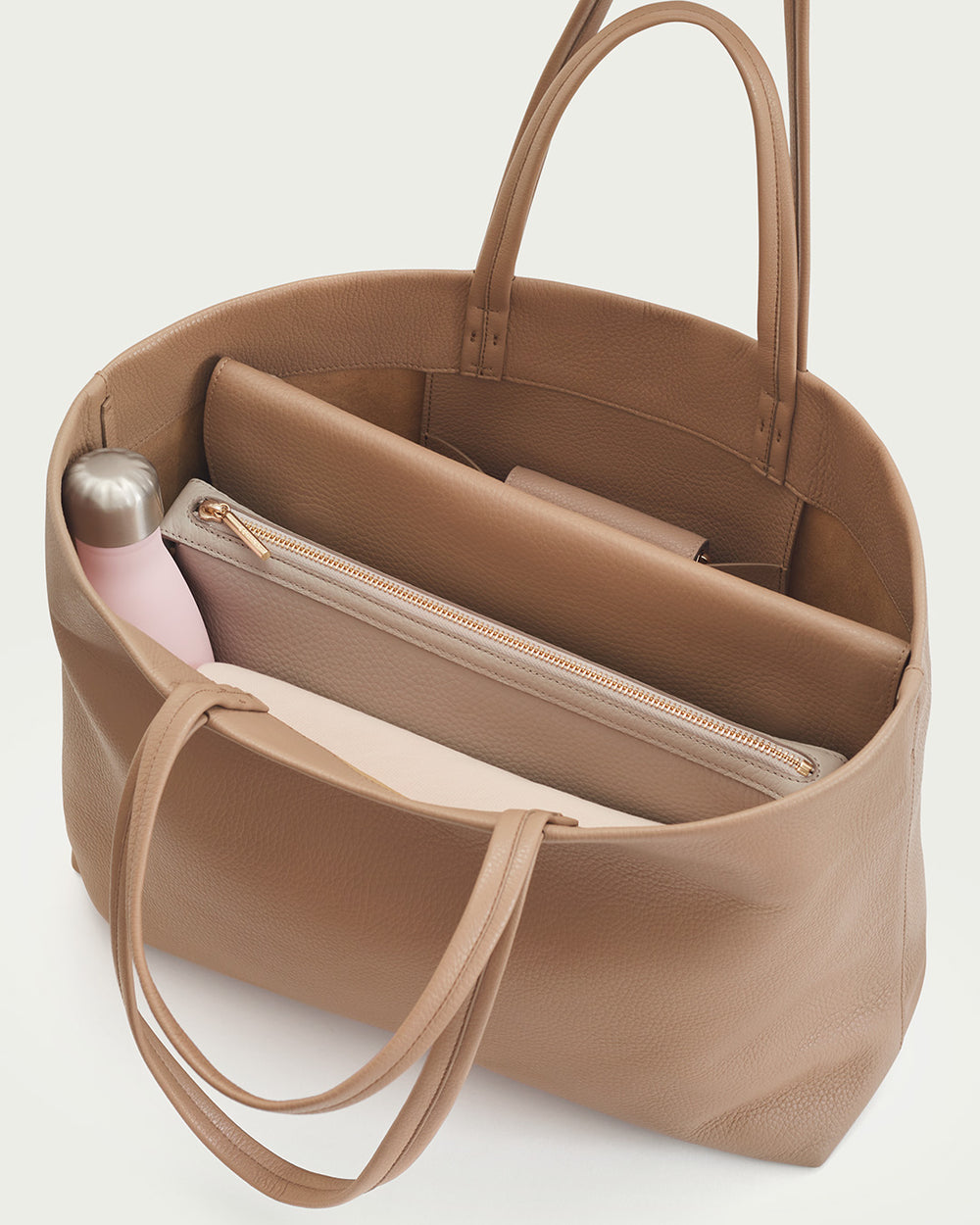 Open handbag showing internal compartments with items inside.