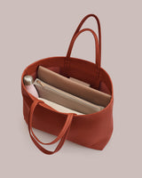 Open tote bag with a water bottle, folders, and a pouch inside.