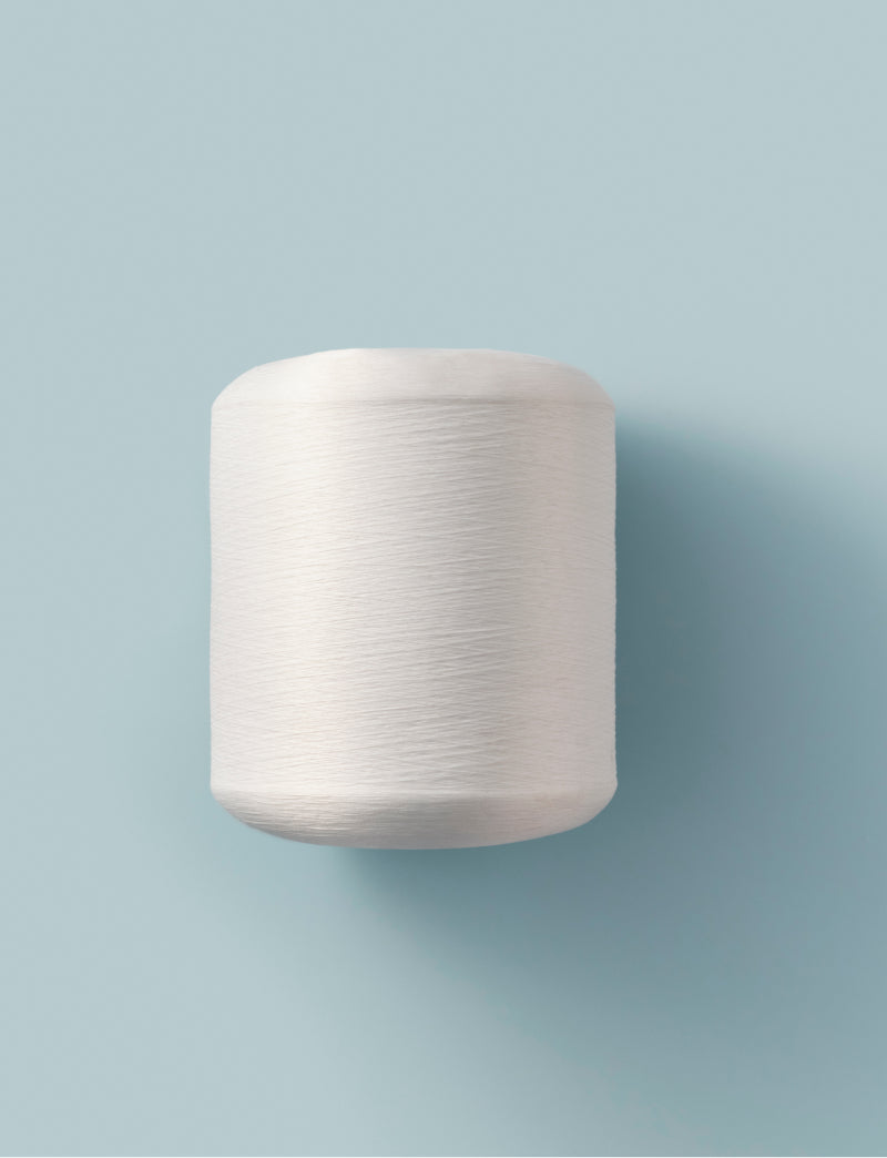 Roll of thread on a plain background.
