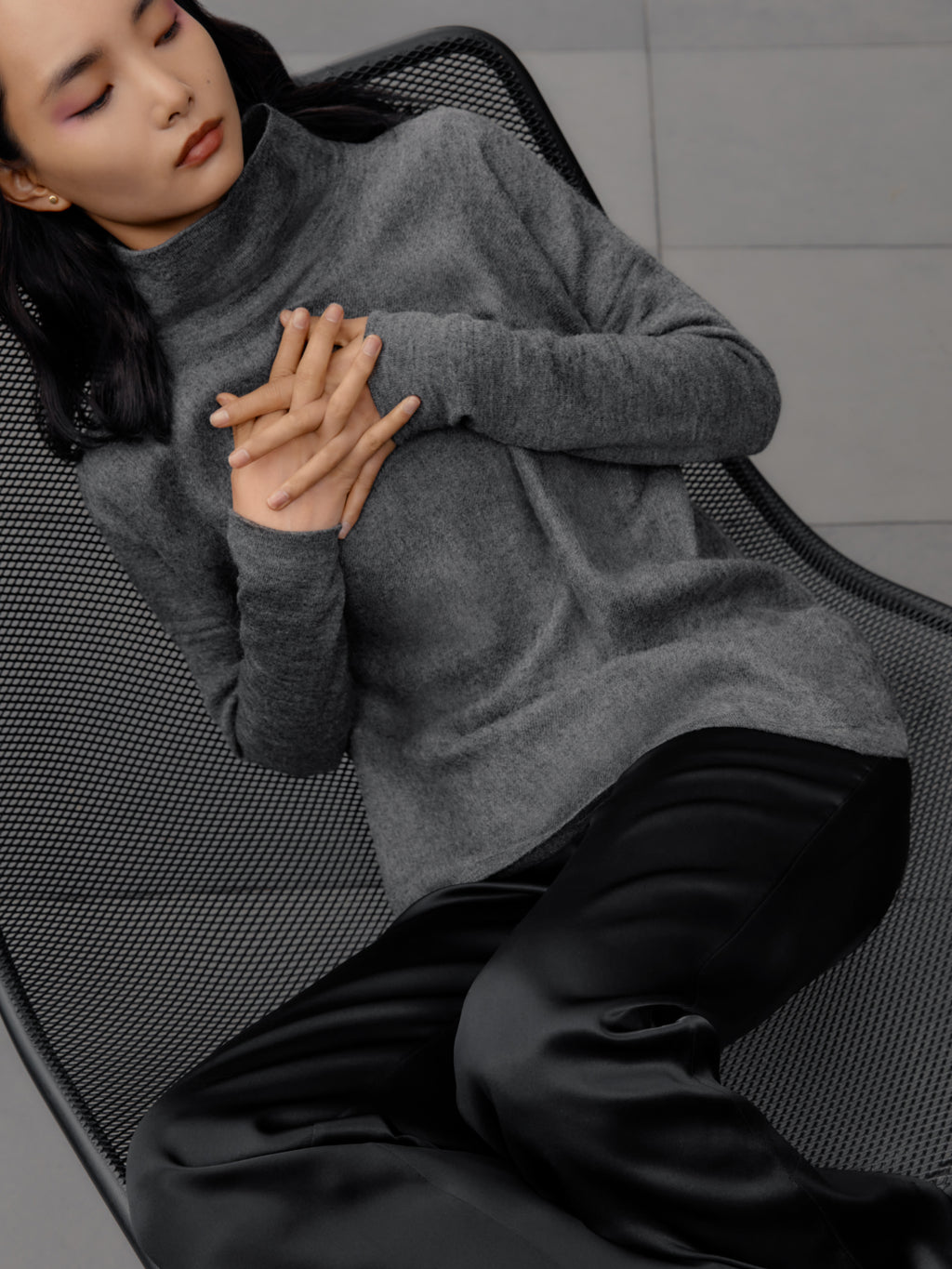Woman reclining on a chair with hands clasped