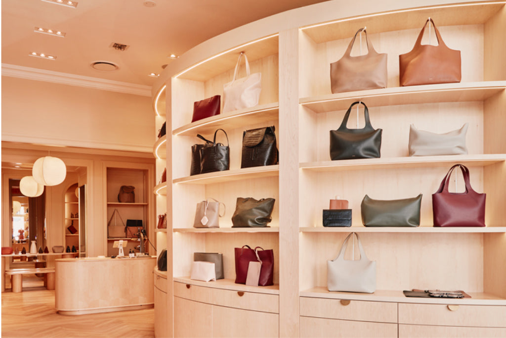 Interior of a store with shelves displaying various handbags.