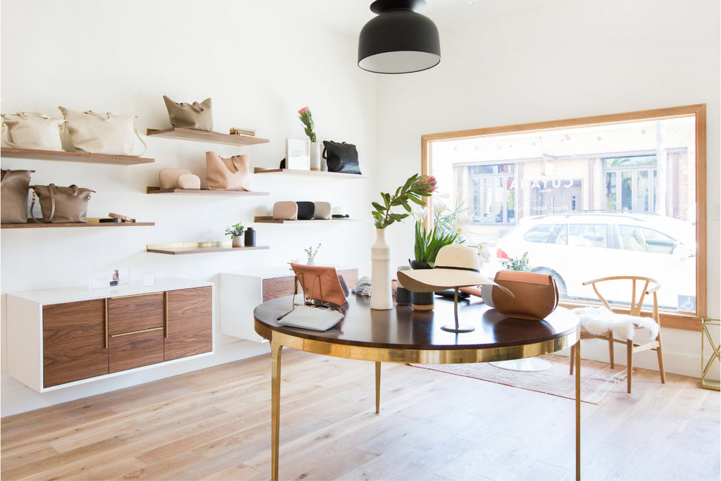 Modern store interior with shelves, a table, chairs, and a lamp