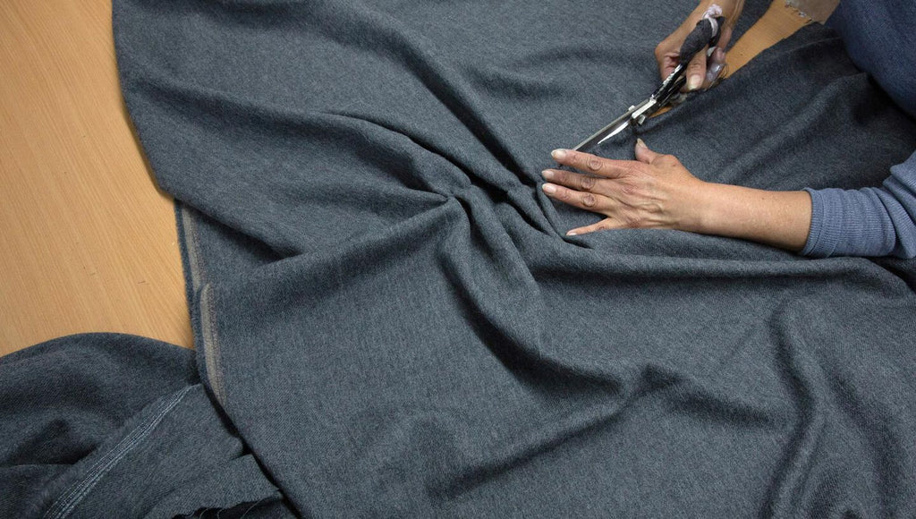 Person cutting fabric with scissors