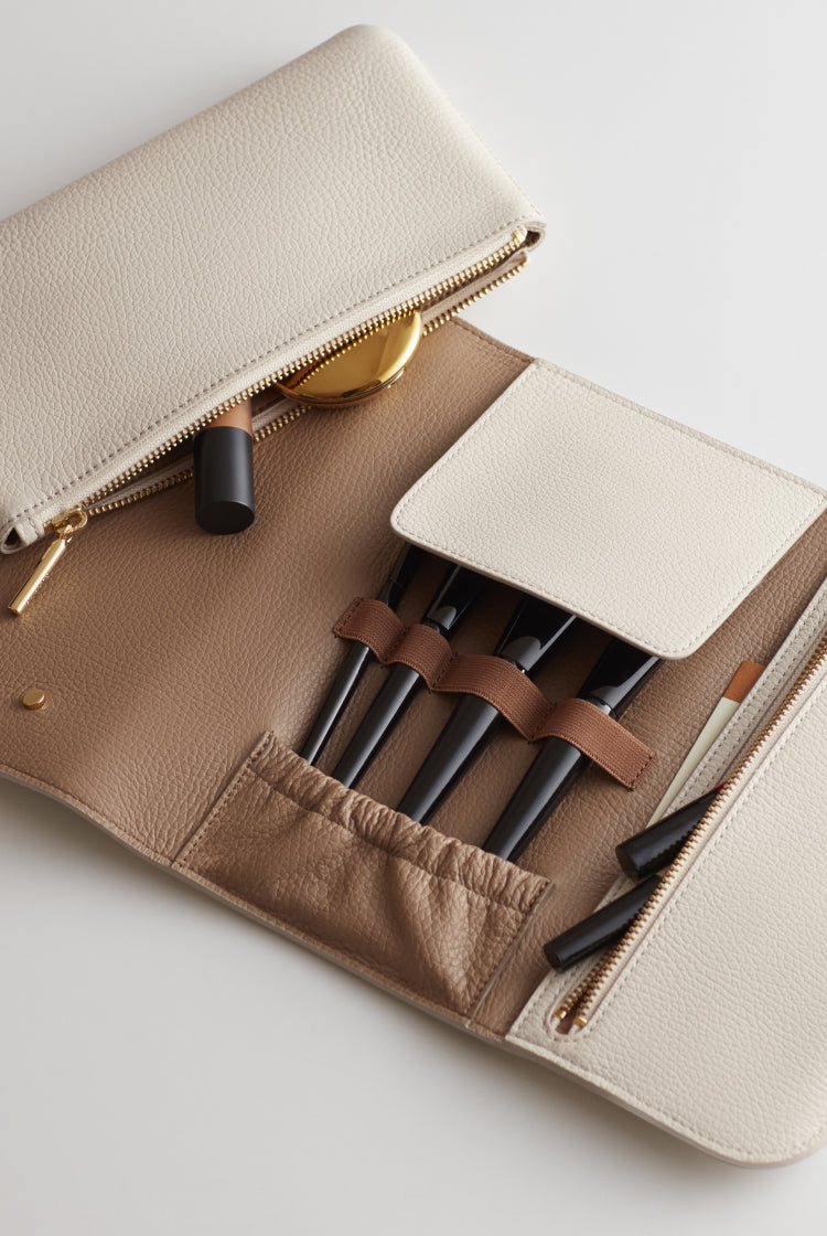 Open organizer with makeup and pens inside.