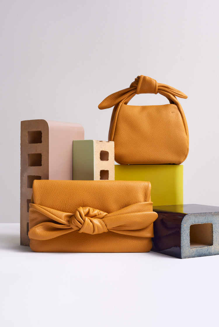 Arrangement of two handbags with assorted blocks on a plain background.