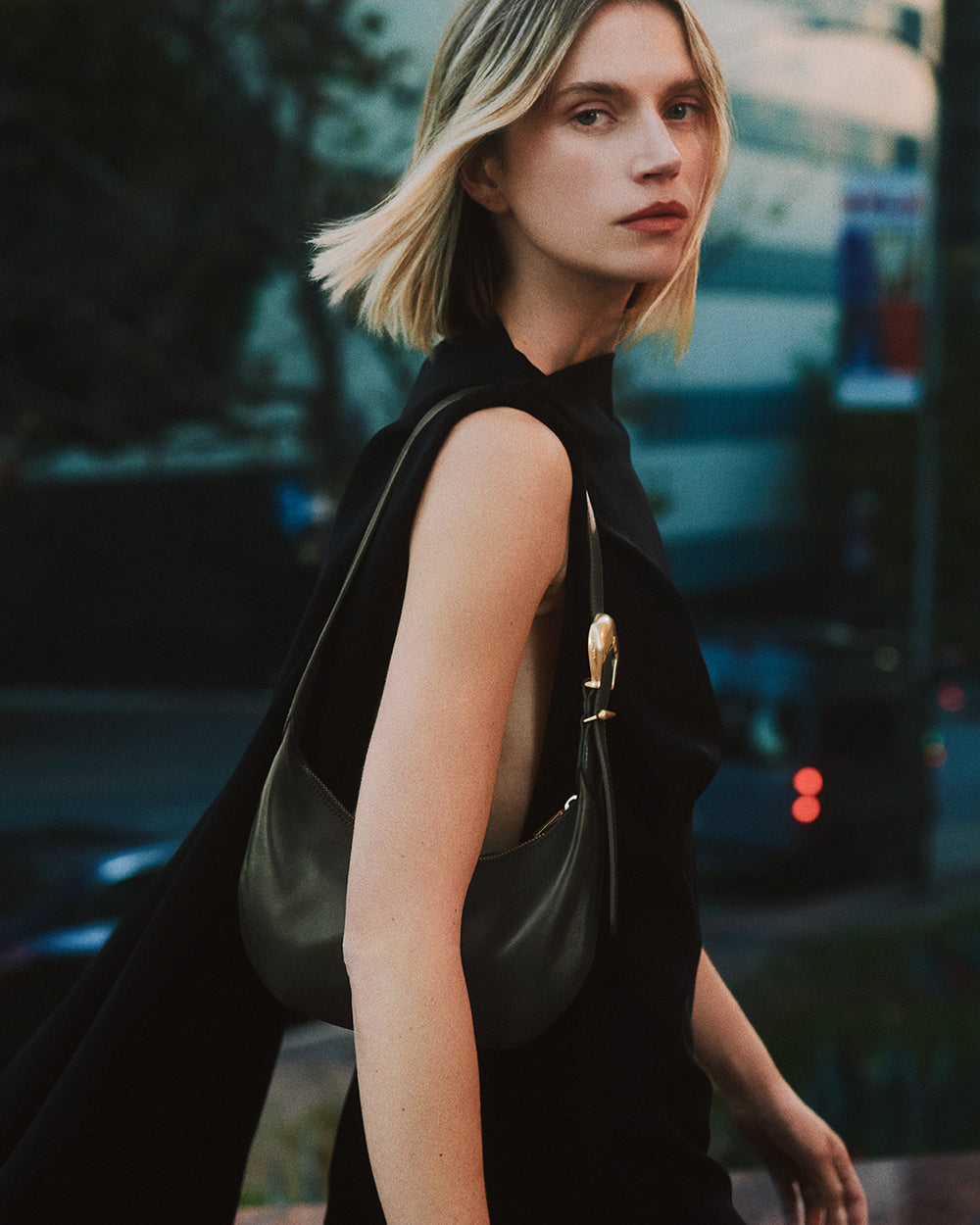 Person walking outside carrying a handbag over shoulder