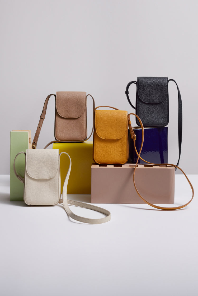 Collection of various handbags arranged against a plain background.