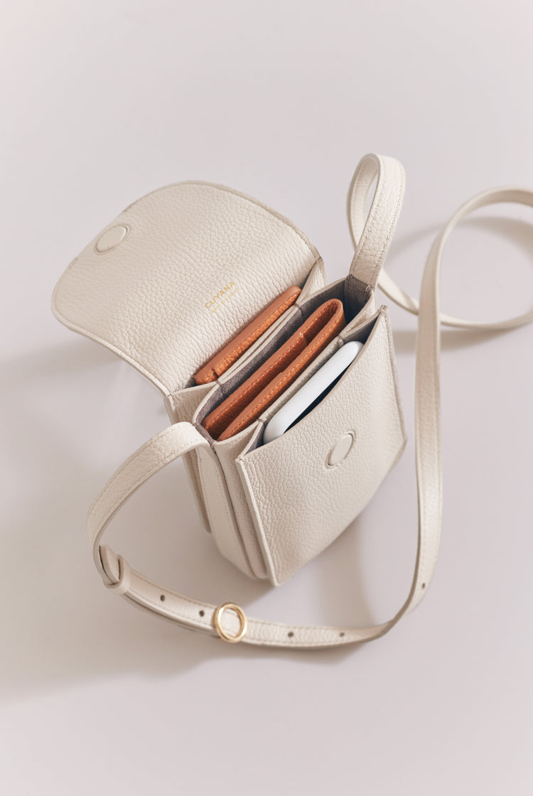 Open handbag with items like a wallet and books inside.