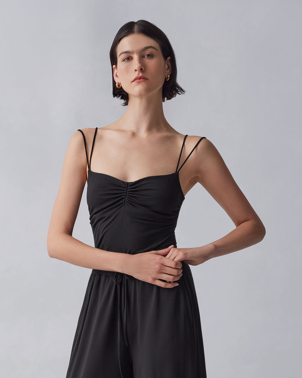 Woman in a sleeveless dress standing with hands on her waist