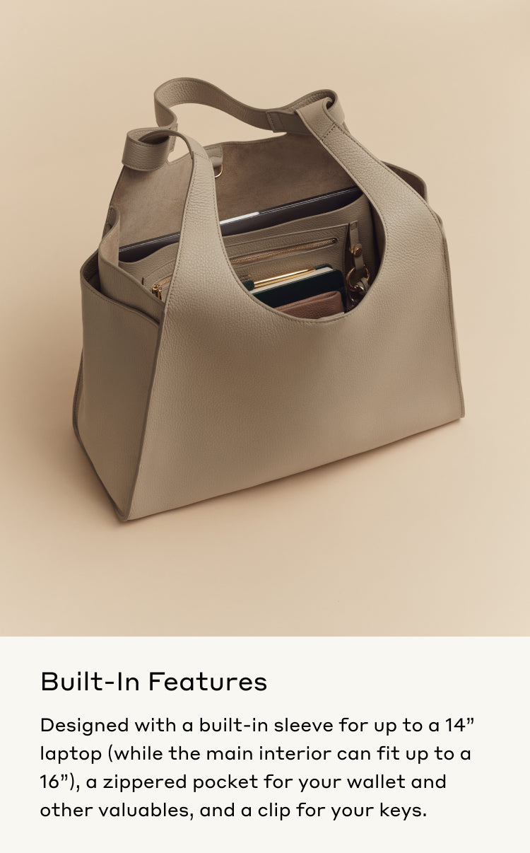 Open handbag with visible compartments and items including a laptop.