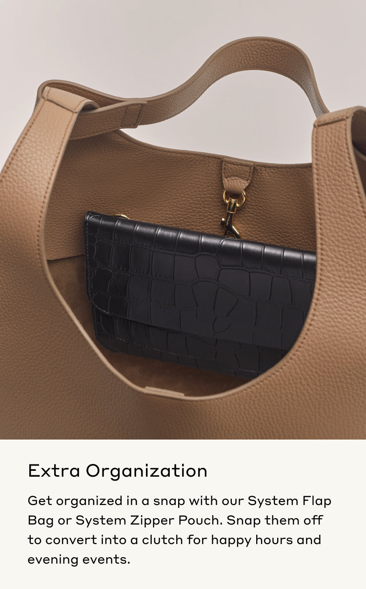 Open handbag with a smaller pouch attached inside by a clip.