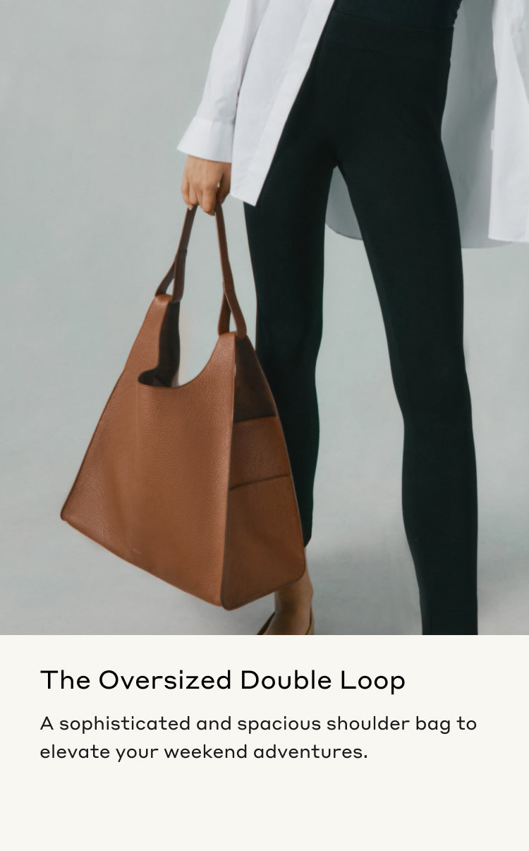 Person holding a large shoulder bag, partially shown, standing upright.