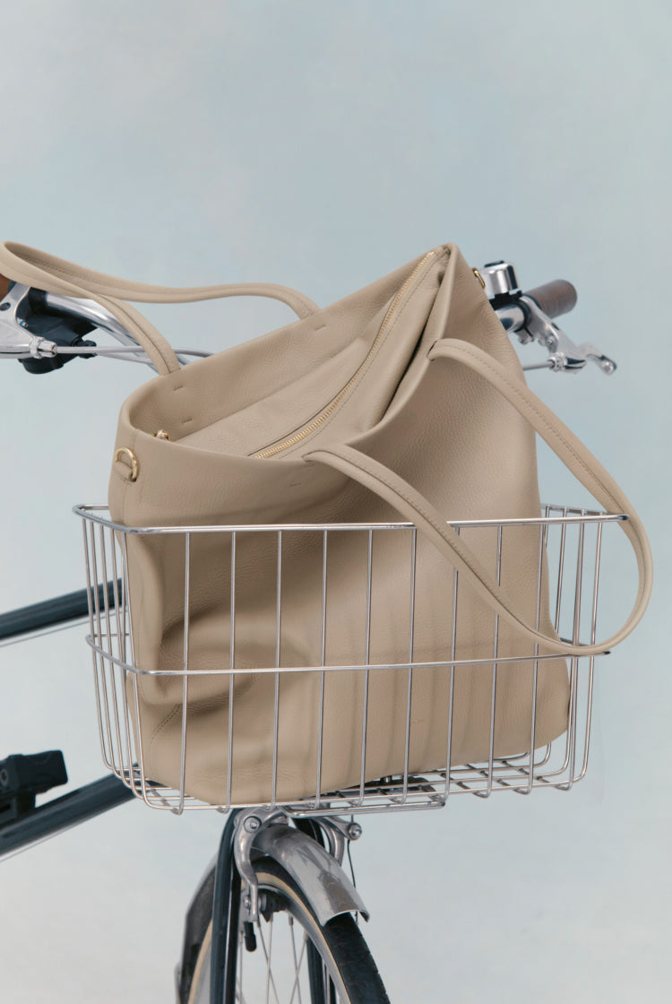 Bag in a bicycle basket with handlebars visible.