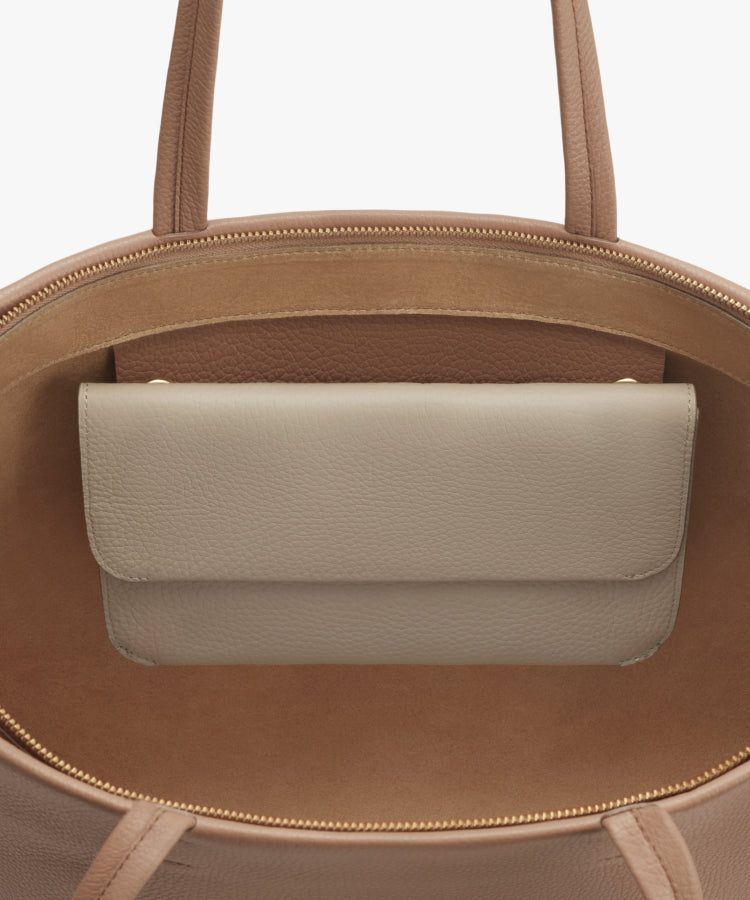 Open top tote bag with a visible inner pouch and smooth exterior.