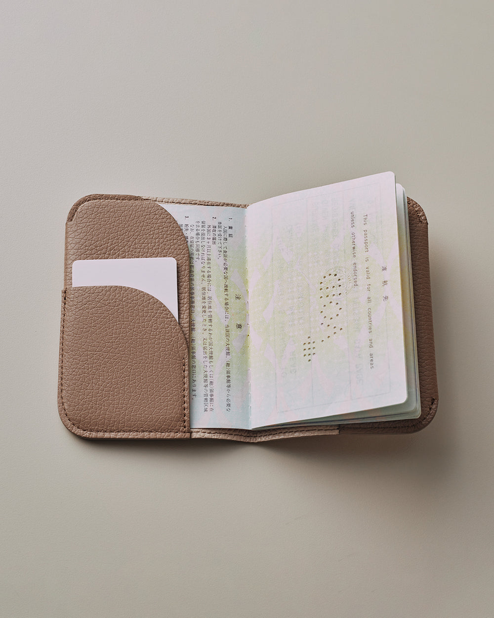 Open passport in a holder with a document inside.
