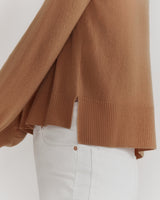 Person wearing a sweater and white pants.