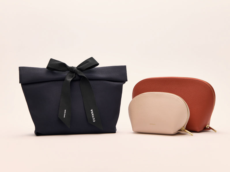 Three pouches on display, one with a ribbon, two rounded.