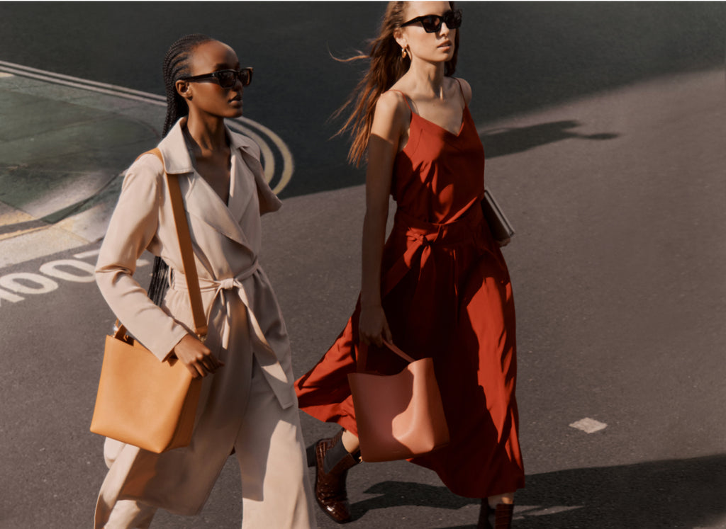 Two women walking on a street during daytime.