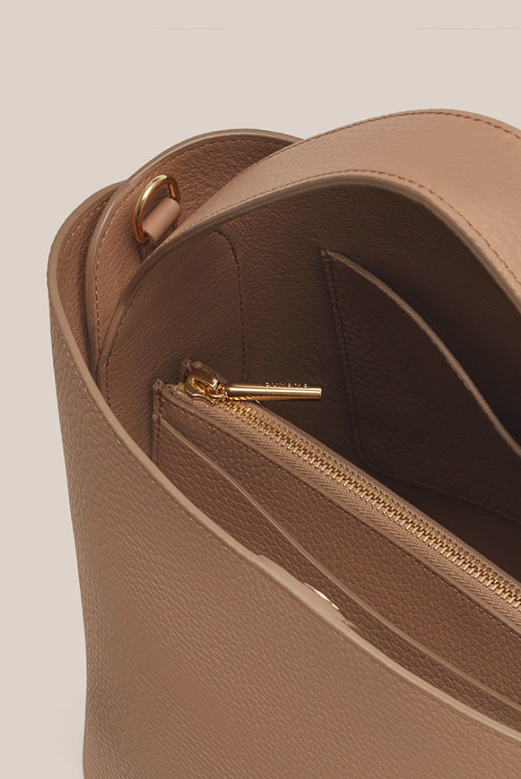 Close-up of an open handbag with a zipper compartment inside.