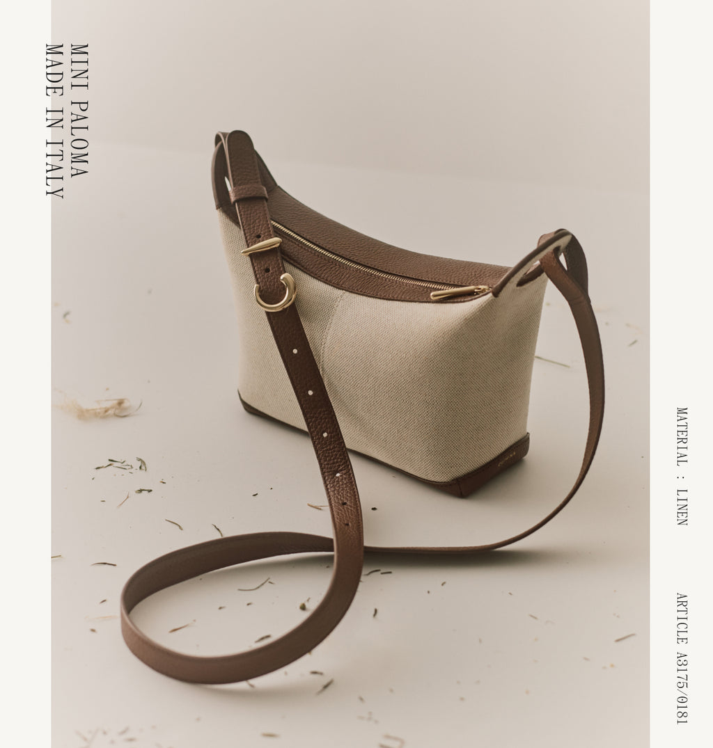 Shoulder bag with long strap on a surface, text around edges.