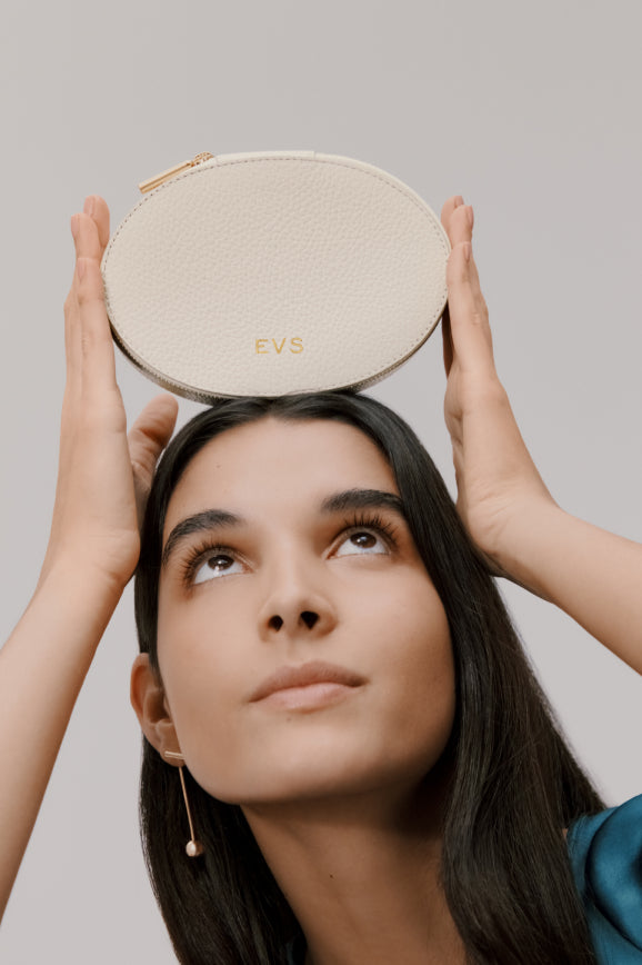 Woman holding a small round object above her head.