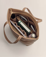 Open handbag with organized compartments and items inside