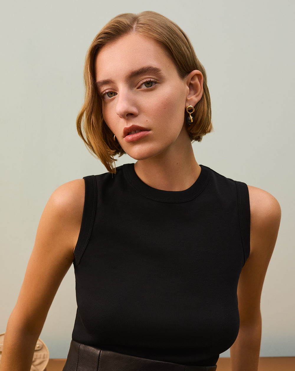 Ola Sphere Earrings Person wearing a sleeveless top with earrings stands indoors.