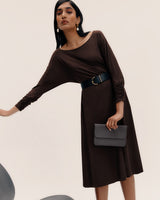 Person in a dress holding a clutch.