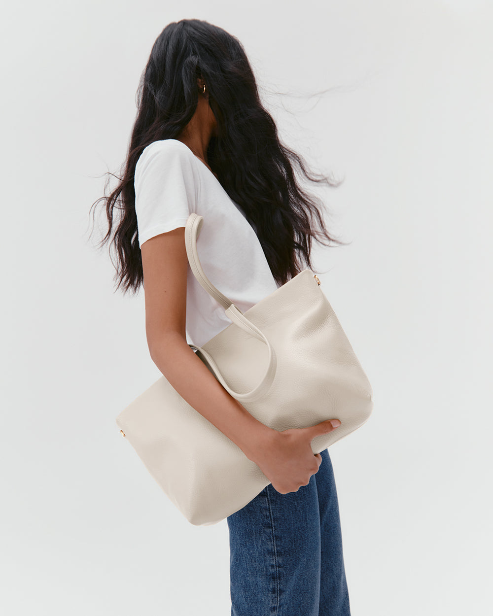 Small Easy Zipper Tote Person with shoulder bag wearing jeans and a tee.