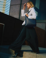 Person walking on steps carrying a large shoulder bag