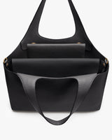 Black handbag with front flap and adjustable strap.