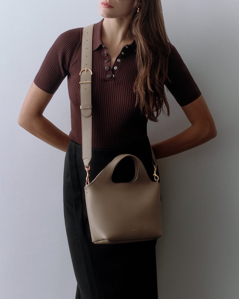 Mini System Tote Person wearing a short-sleeve shirt and skirt with a shoulder bag.