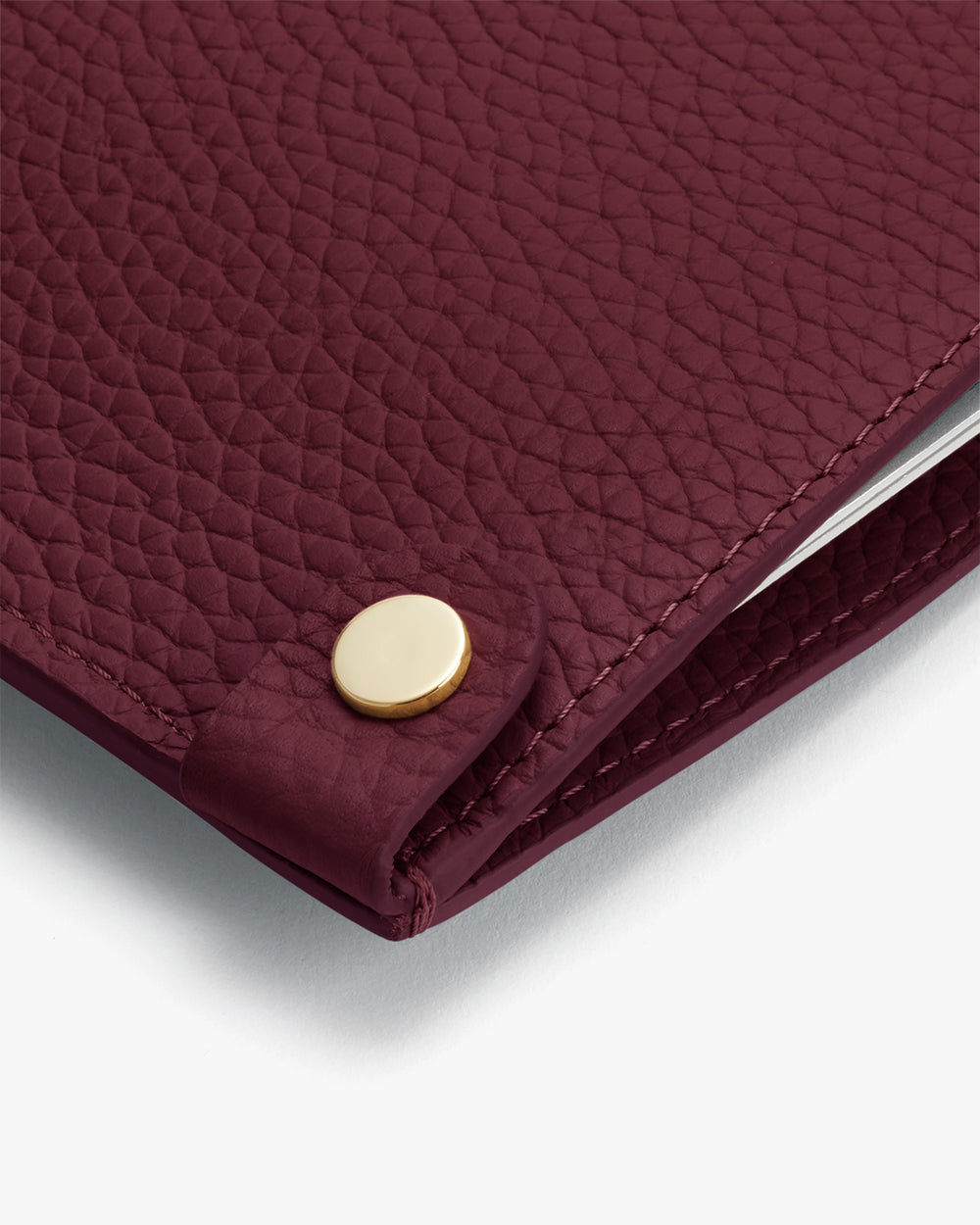 System Laptop Sleeve 13-inch Close-up of a textured leather item with a metallic stud.