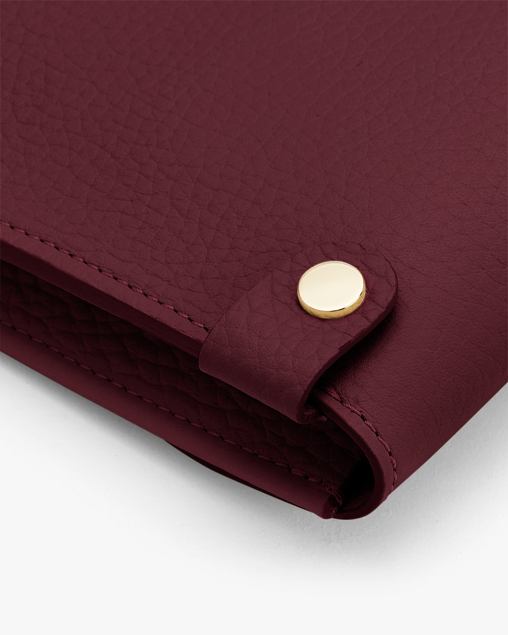 Tech Carryall 16-inch Close-up of a folded corner of a textured leather item with a button.