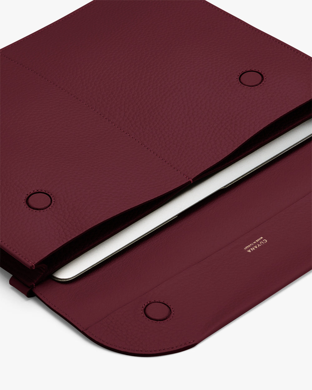 Open laptop sleeve with a tablet partially inserted and magnetic closures.