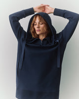 Person wearing a hoodie with arms raised above the head