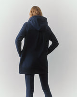 Person facing away wearing a long hoodie and pants.