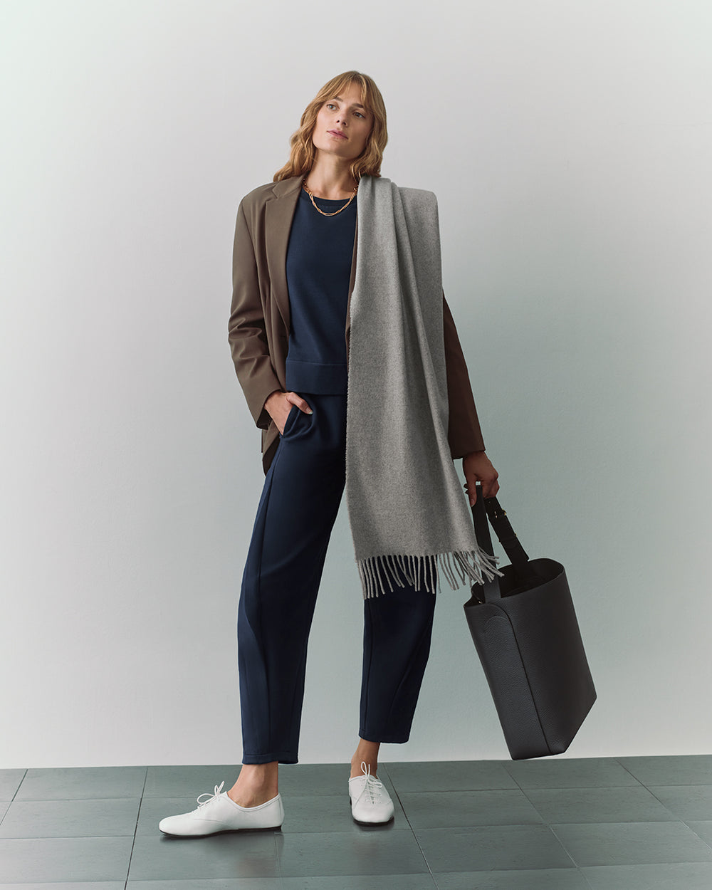 Fleece Cropped Sweatshirt Person in suit with a scarf and a large tote bag.
