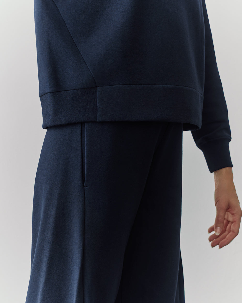 Fleece Cropped Sweatshirt Person in a relaxed fit outfit, cropped image of torso and hand.