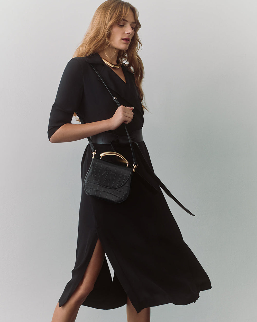 Woman in dress carrying a small shoulder bag