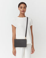 Person wearing a simple outfit with a crossbody bag