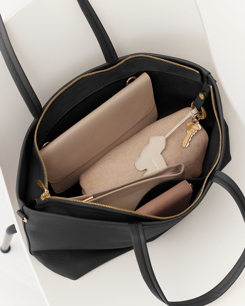 Open tote bag with a wallet, pouch, and keys inside.