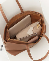 Open tote bag with a wallet, pouch, and keys inside.