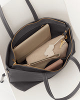 Open tote bag with a wallet, pouch, and keys inside.