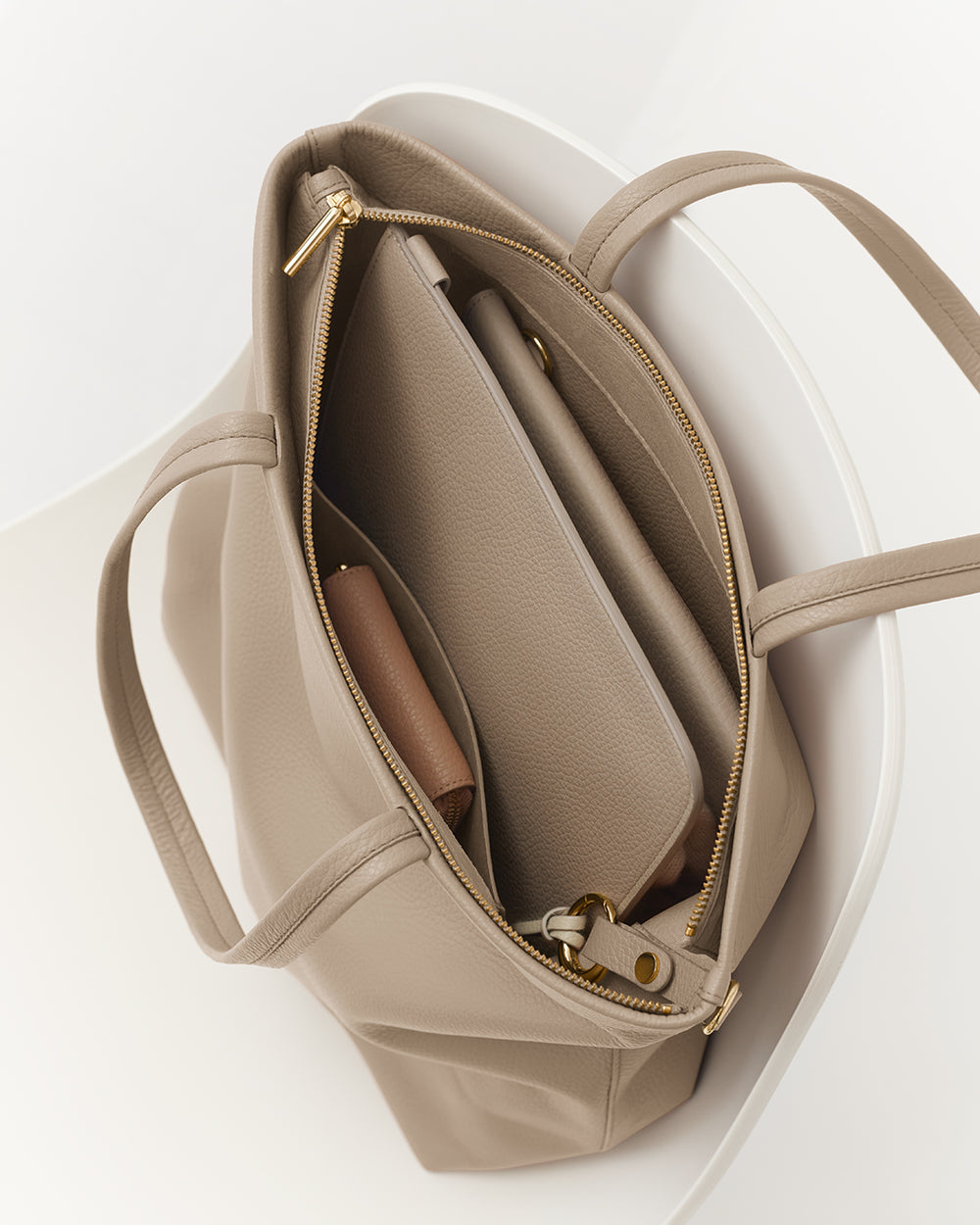 Open totel bag with a tablet and a small pouch inside.
