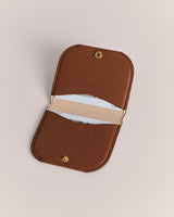 Open leather cardholder with two cards inside.