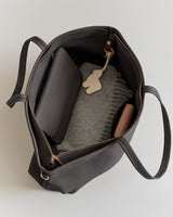 Open tote bag with a wallet, scarf, and keychain inside.