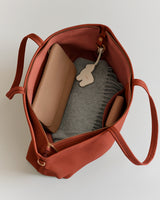 Open tote bag with wallet and fabric inside.