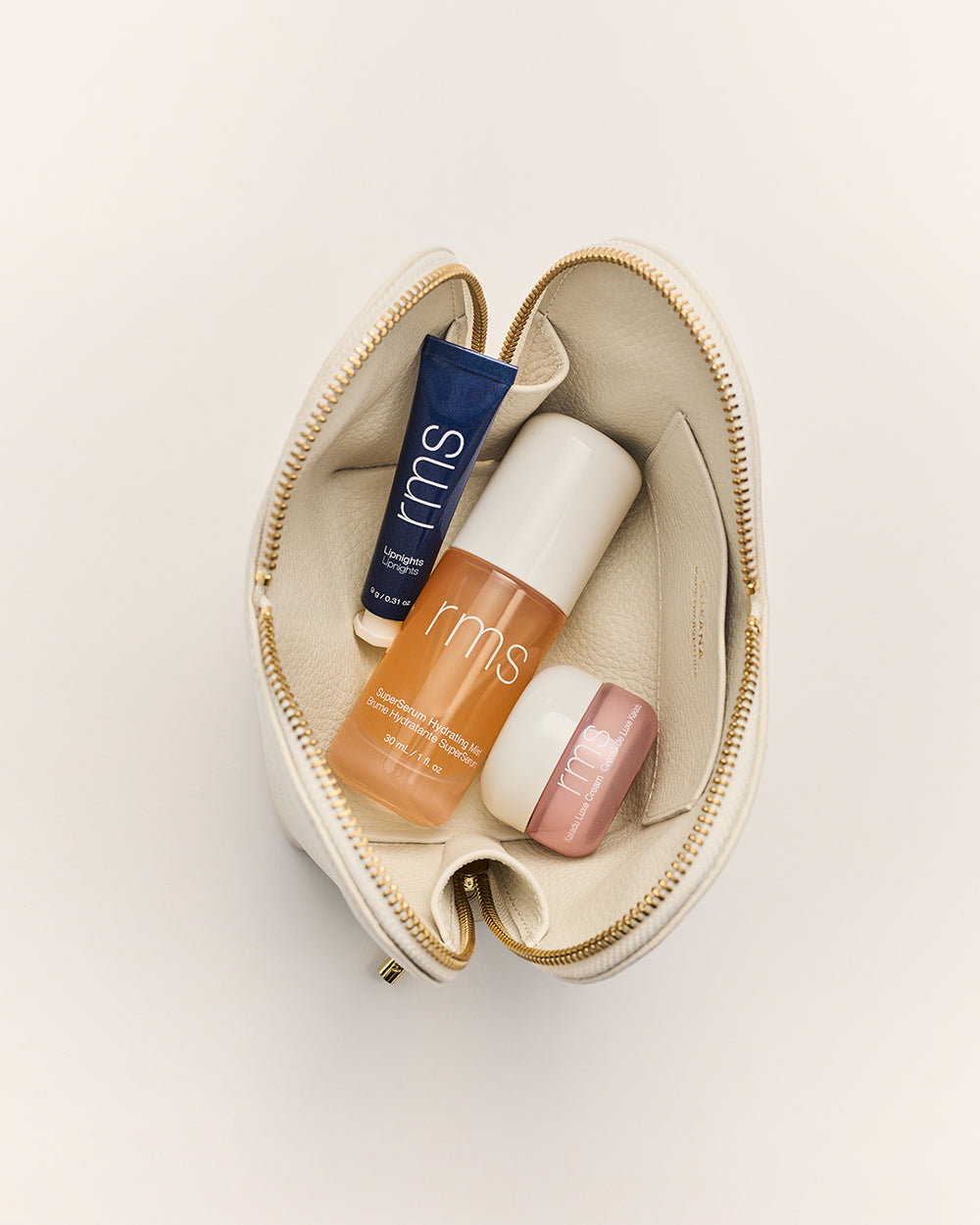 Open makeup bag with lip balm, moisturizer, and skin serum inside