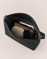 Open travel bag with pouches, sunglasses, and a phone inside.